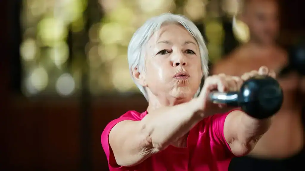 Toning Arms After 60: Empowering Womens Fitness Through Effective Weight Training 1 Older woman doing weight training West Drayton to help her strength and longevity