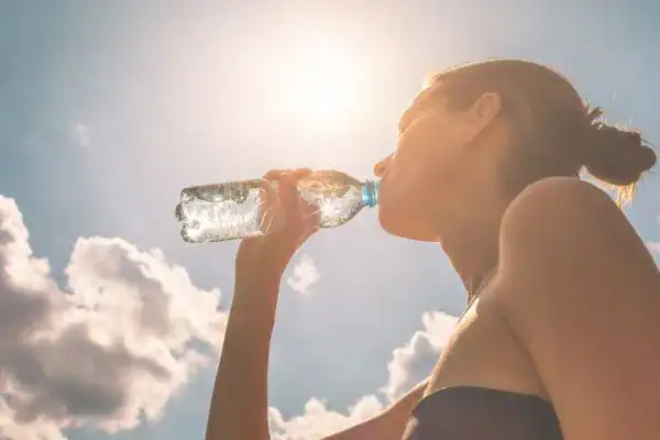 Hydration: The Secret Ingredient for a Toned Stomach and Enhanced Fitness 3 Image of woman drinking water to hydrate West Drayton after run.