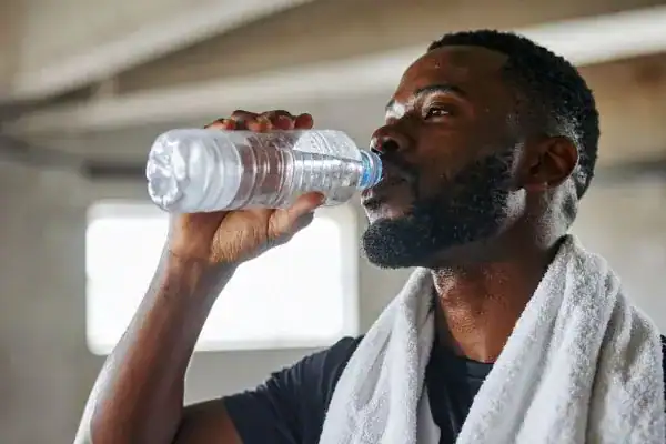 Hydration: The Secret Ingredient for a Toned Stomach and Enhanced Fitness 1 Image of man drinking water to improve hydration West Drayton after work out.